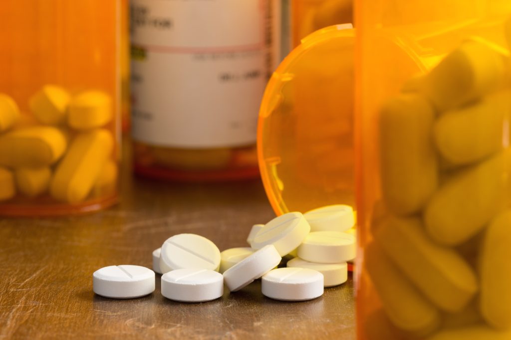 Medicine bottle and tablets spread out on a surface