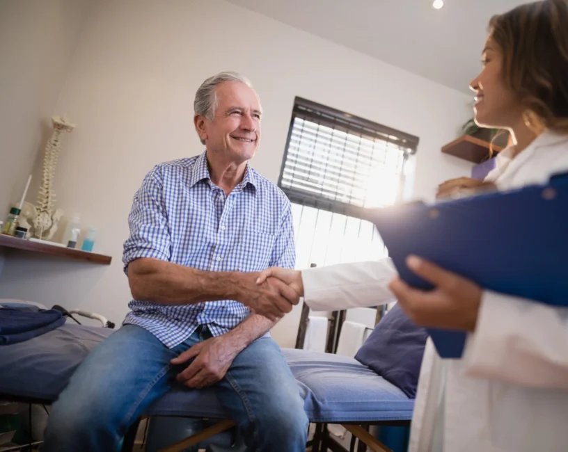 A doctor and an older man shaking hands